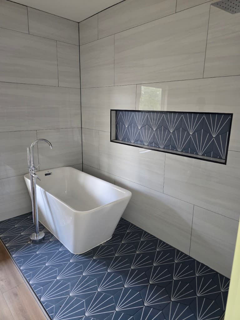 Bathroom renovation in progress showing updated tub and plumbing fixtures